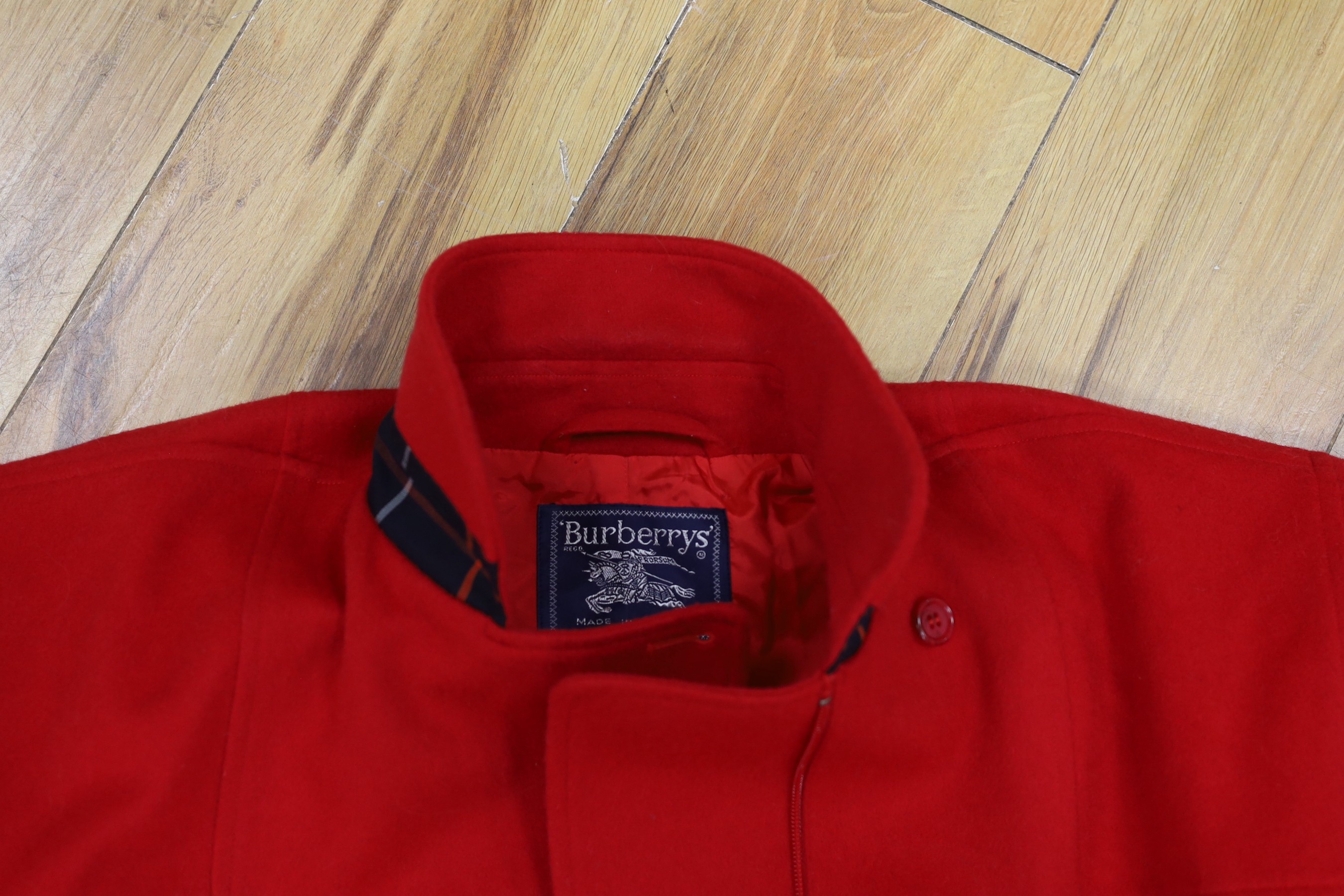 Two vintage Burberry items of clothing: a pleated skirt and a red Harrington jacket